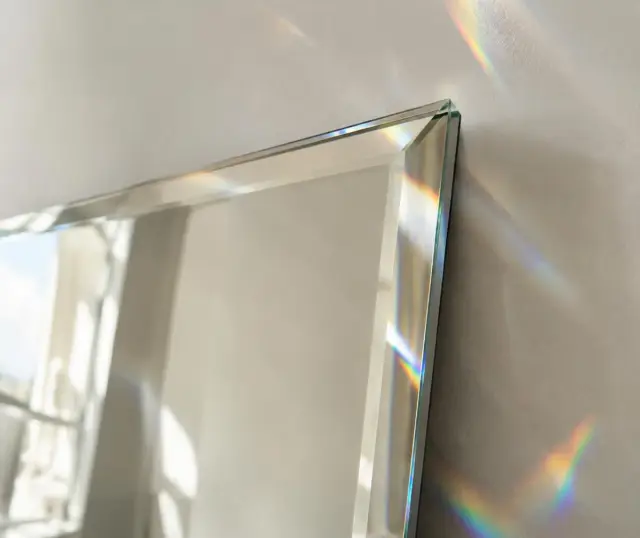 Detalle de espejo biselado con reflejos de luz (imagen ilustrativa)